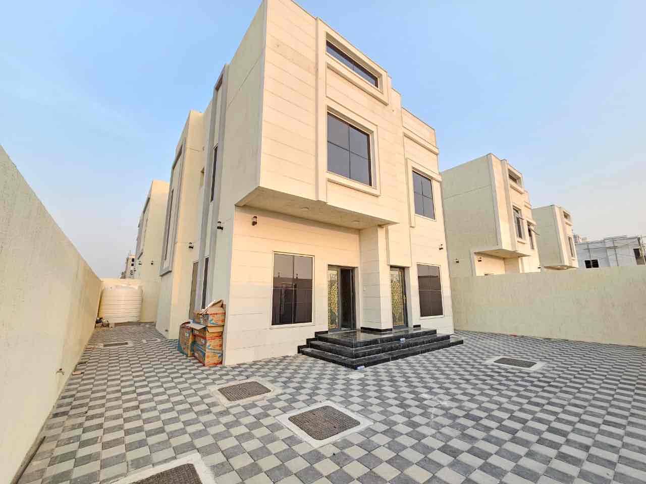 A villa for rent in Ajman, Al Bahia area, consisting of two floors and has a living room, a hall, a kitchen, and 3 master bedrooms, ready for living, with air conditioning, electricity and water included. 90 thousand negotiable direct
