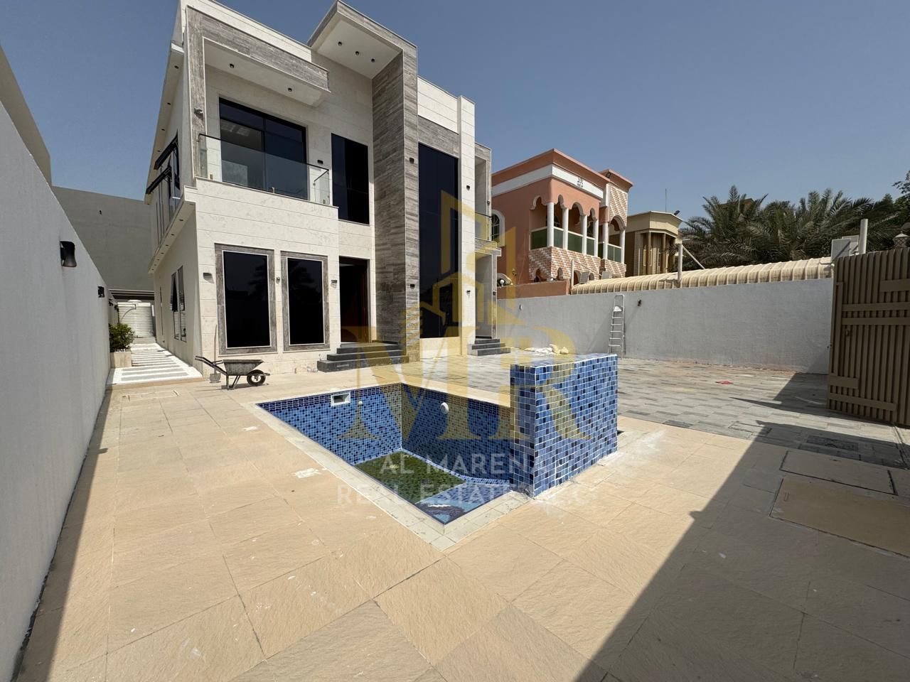 Villa for sale in Ajman, Al Rawda area. The villa consists of 5 master bedrooms, a majlis, a hall, a maid's room, and a large swimming pool.