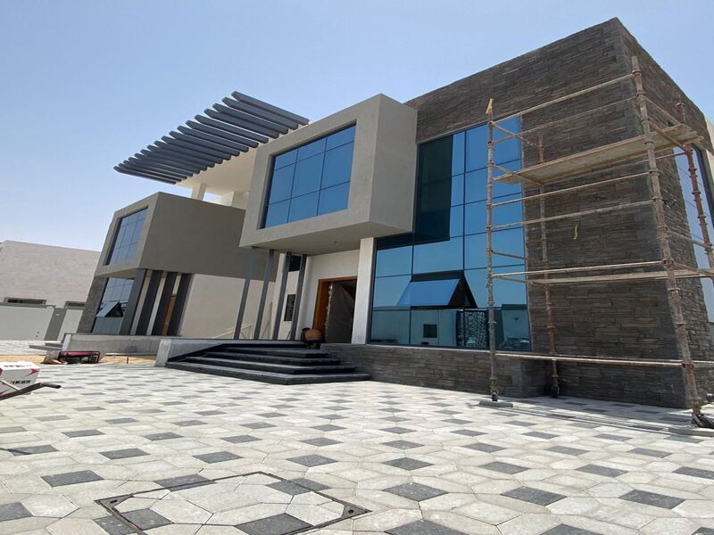 Two villas for sale in Al Houchi, near Emirates Road. Ground floor + first floor Each villa consists of 5 bedrooms, a living room, a lounge, a maid's