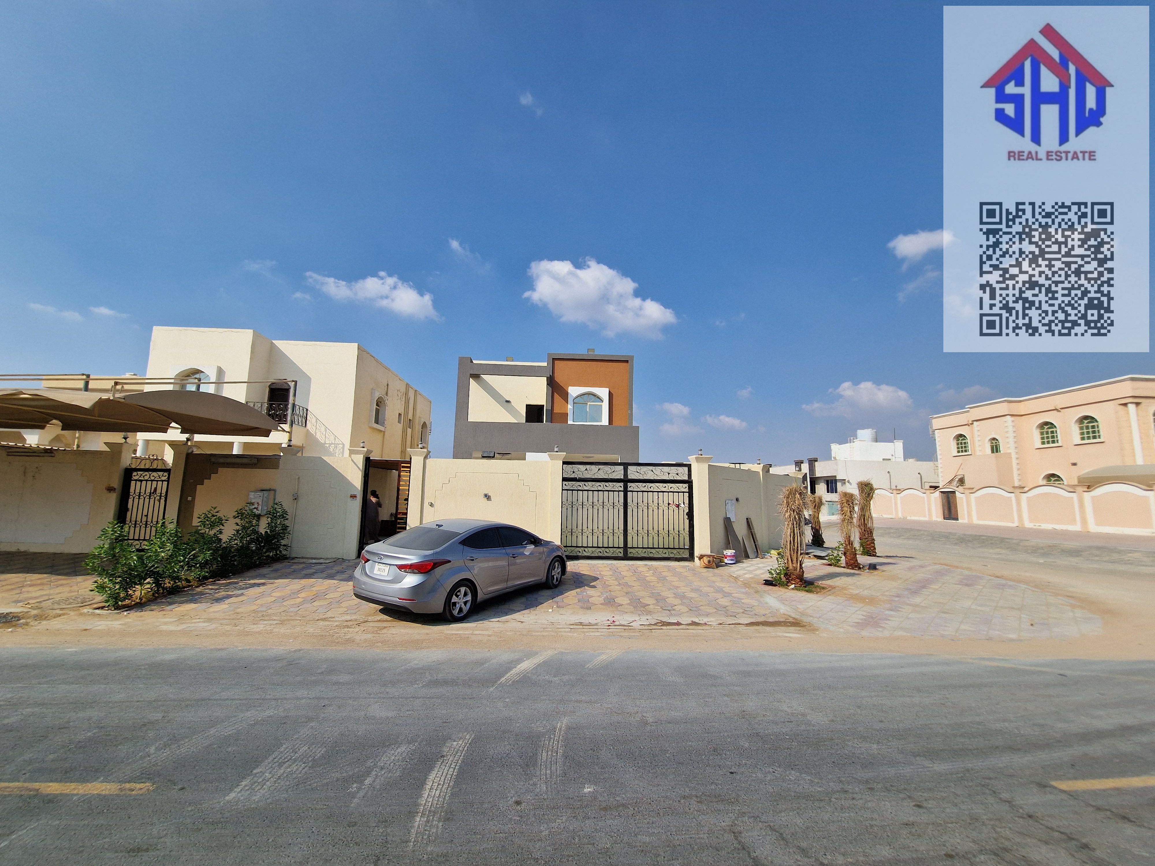 Corner villa for sale with garden and dressing room, including water, electricity, and air conditioning. Five bedrooms, living room, maid's room, outdoor majlis with shade, and indoor seating area.