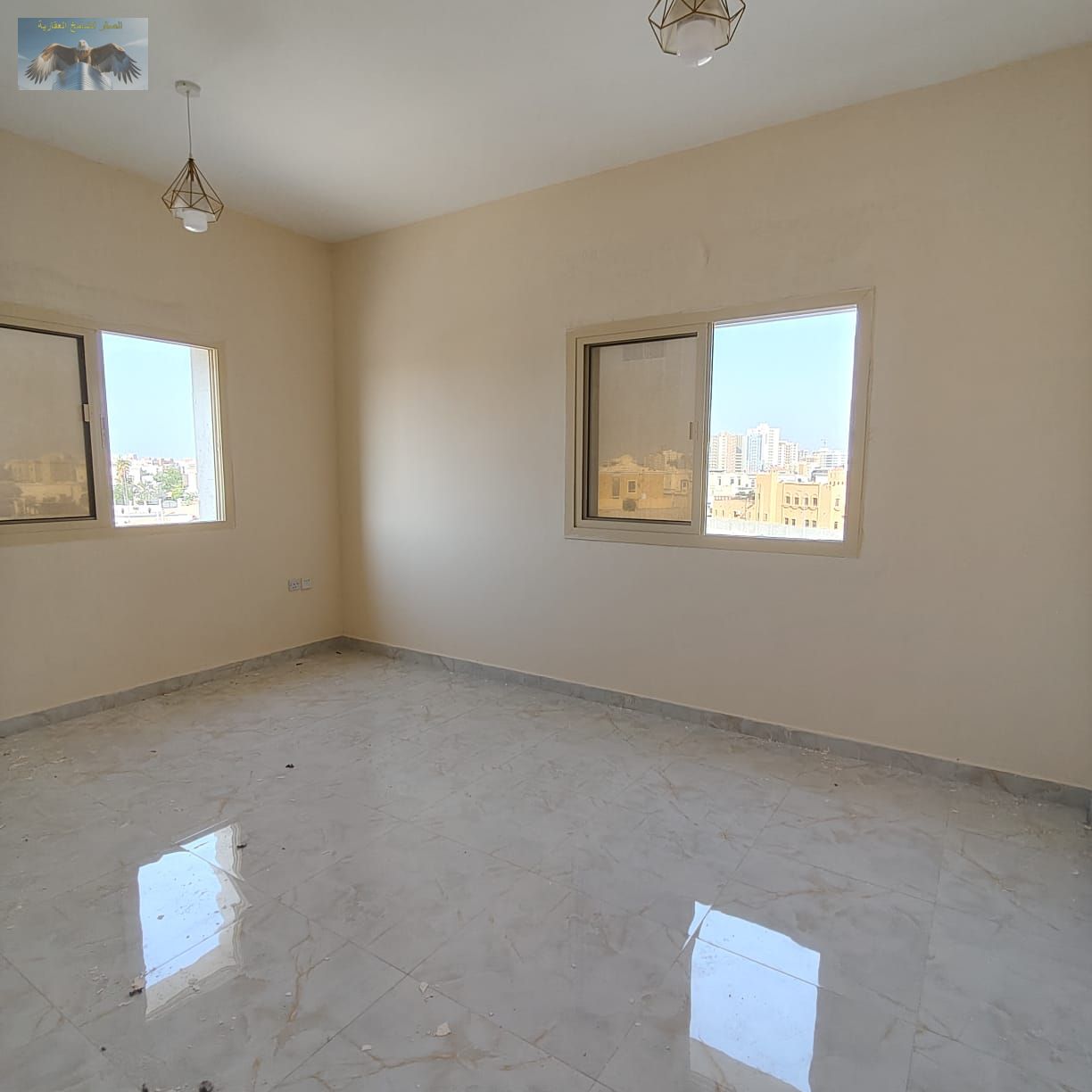 Spacious two-bedroom apartment for rent in Al Jurf 2, near the National School, fully finished building with central AC, balcony, and open view