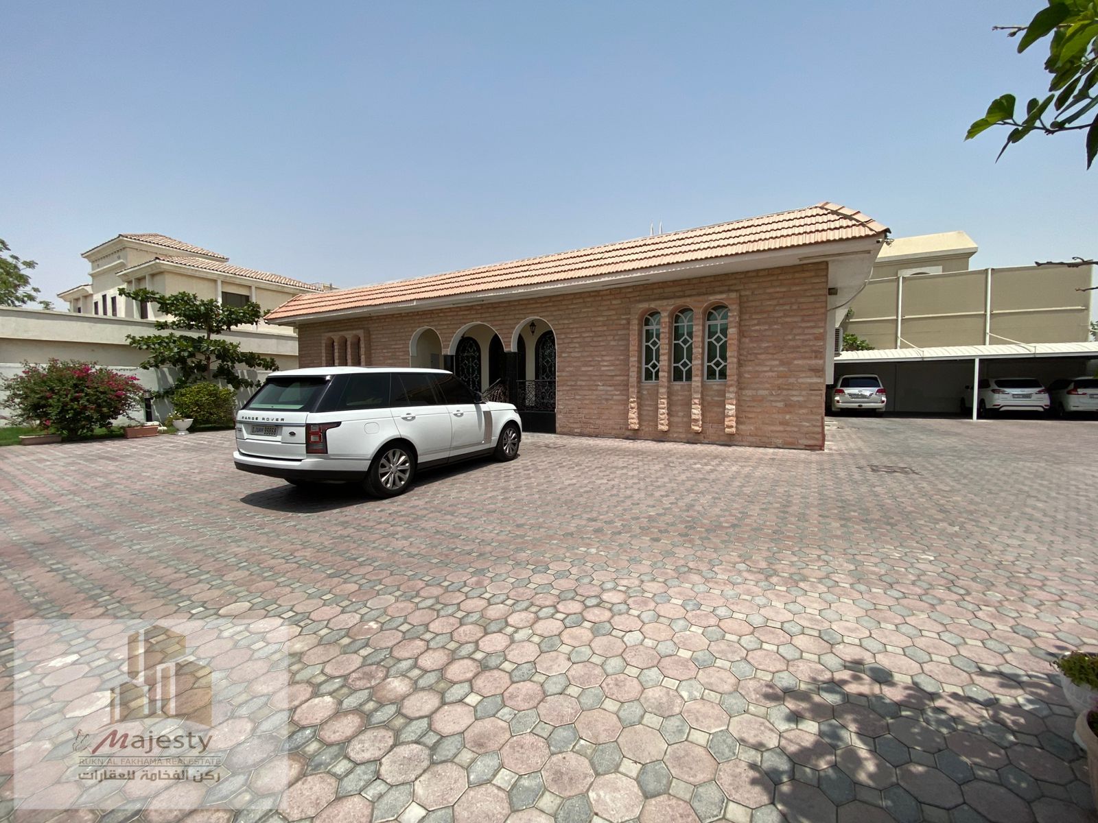 Luxury single-story villa for sale on two streets in Al Ramaqiya, Sharjah, 13,000 sq. ft, with annex, garden, outdoor seating, and parking, AED 2,250,0