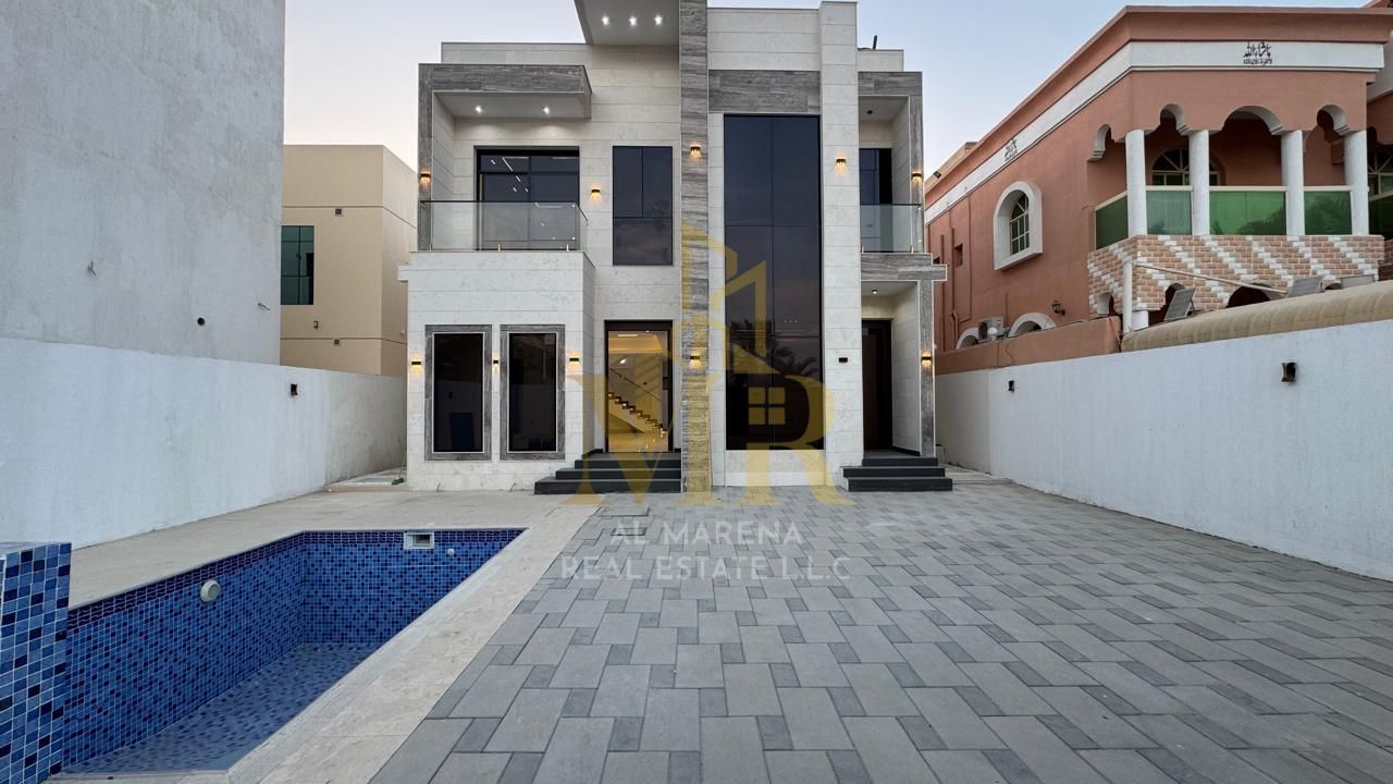 Villa for sale in Ajman. The villa is a G+1 (ground floor plus one) with electricity and water included, featuring 5 master bedrooms, a majlis (formal