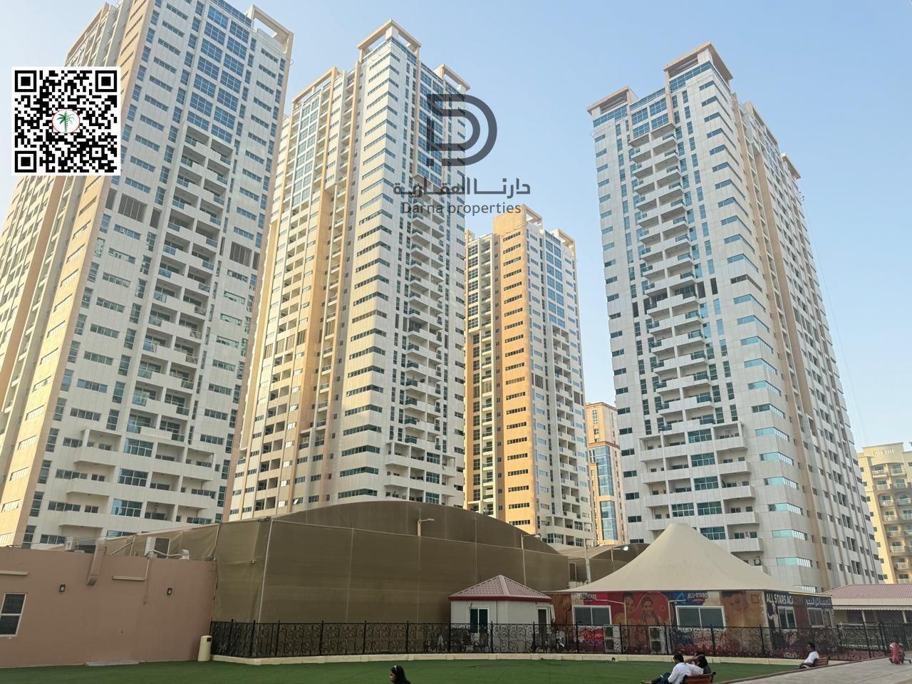 two-bedroom apartment with a living room for sale in Ajman One Tower with a city and garden view