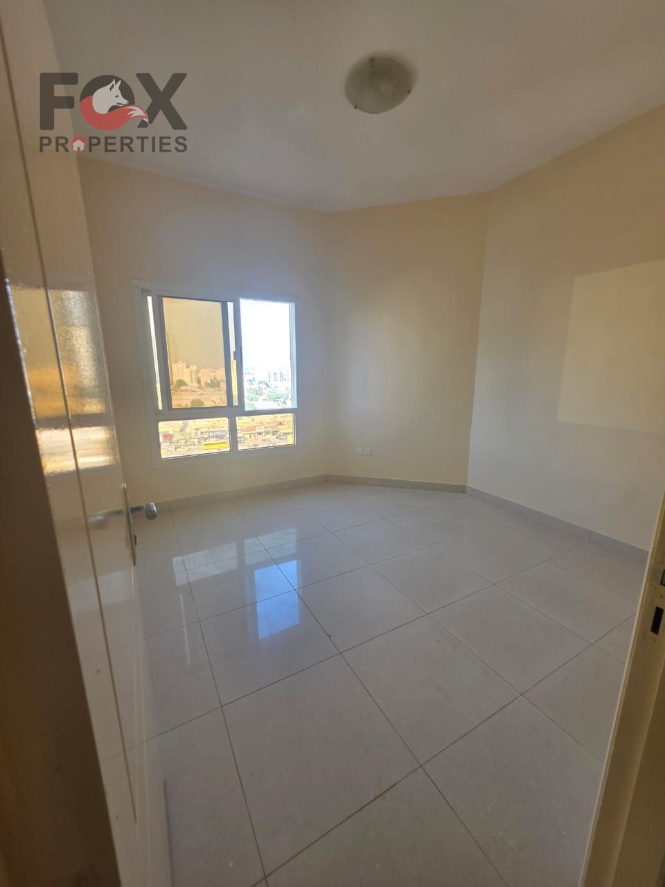Two-bedroom apartment with a living room, 2 bathrooms, open view, prime location on a main road near services, easy access to Sharjah & Dubai