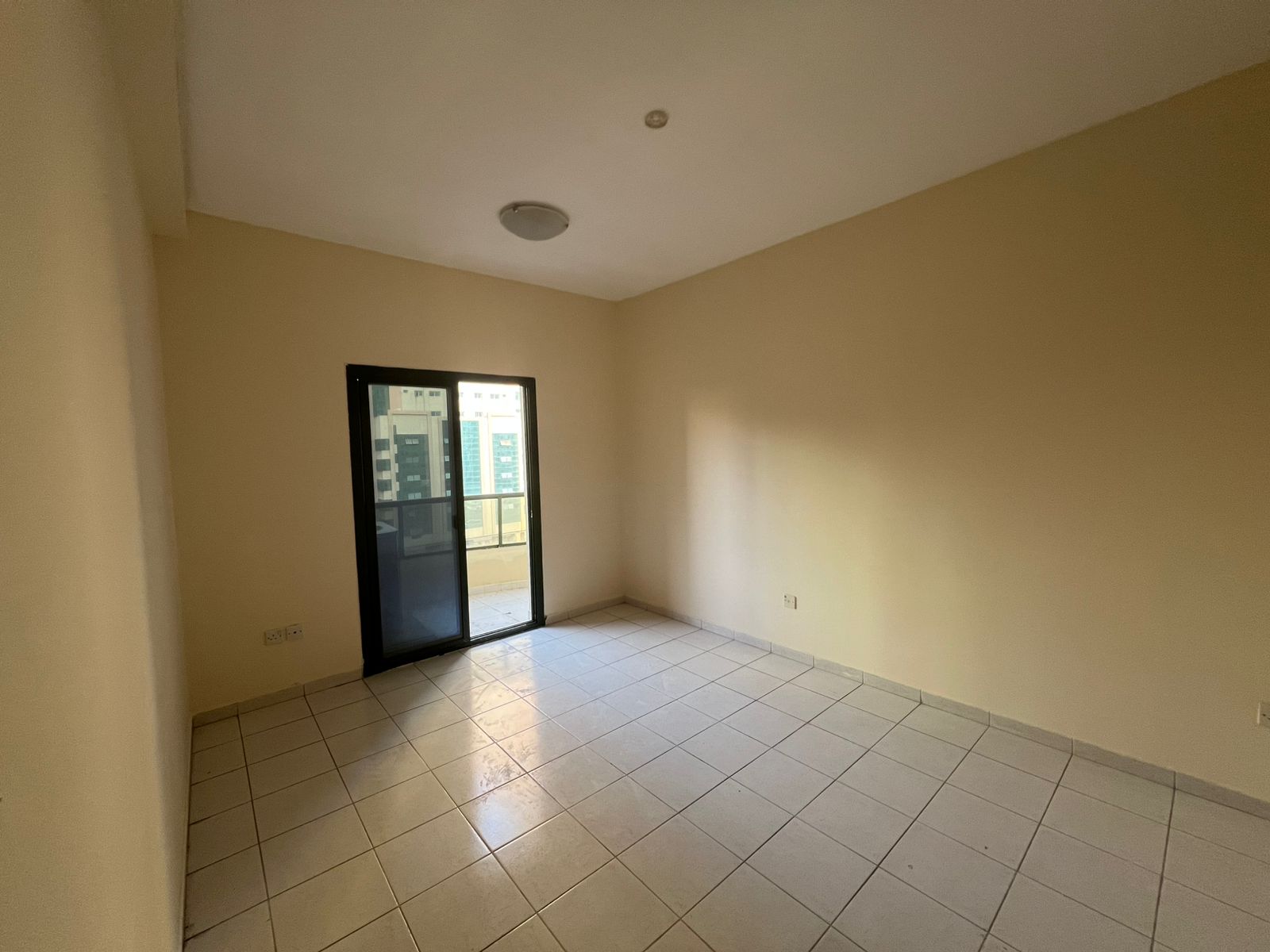 Two-bedroom apartment in Al Nahda Sharjah with balcony, Sahara Centre view, built-in wardrobes, two bathrooms, fully maintained.