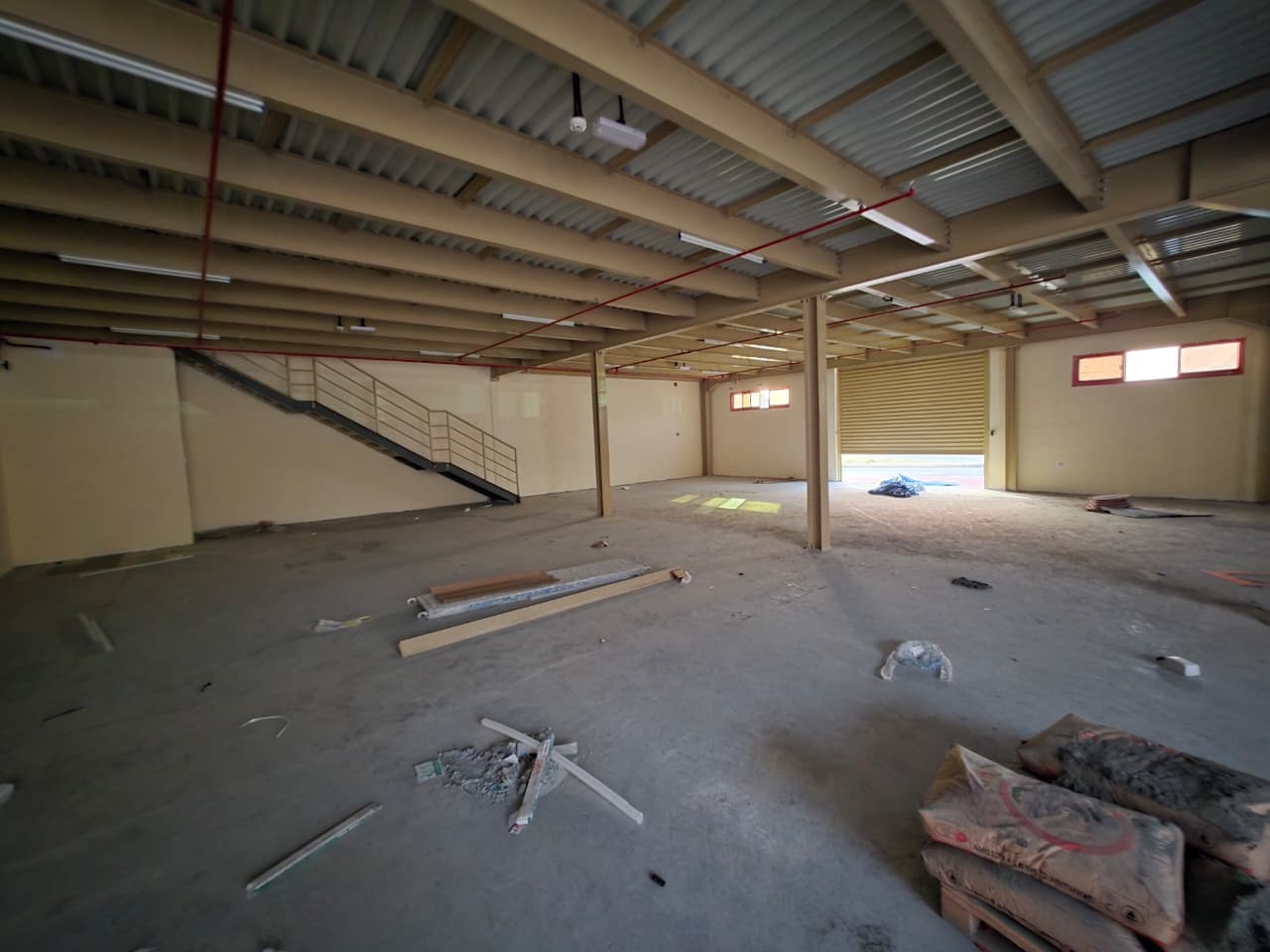 Warehouse for rent in Ajman Al Jurf Industrial 1, 6,000 sq ft with new mezzanine, suitable for commercial activities, annual rent 310,000 AED.