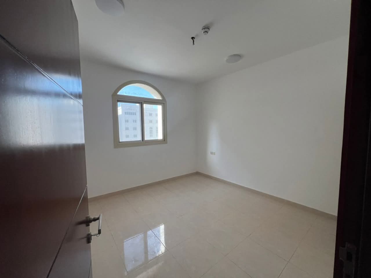For annual rent in Sharjah, Al Quliah area, first tenant, one bedroom, living room, 2 bathrooms, and balcony. Prime location, very close to Sharjah Co