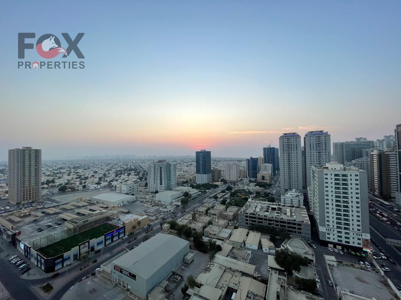 A spacious one-bedroom apartment with a living room in City Towers, featuring panoramic views of Grand Mall and Khalifa Street.