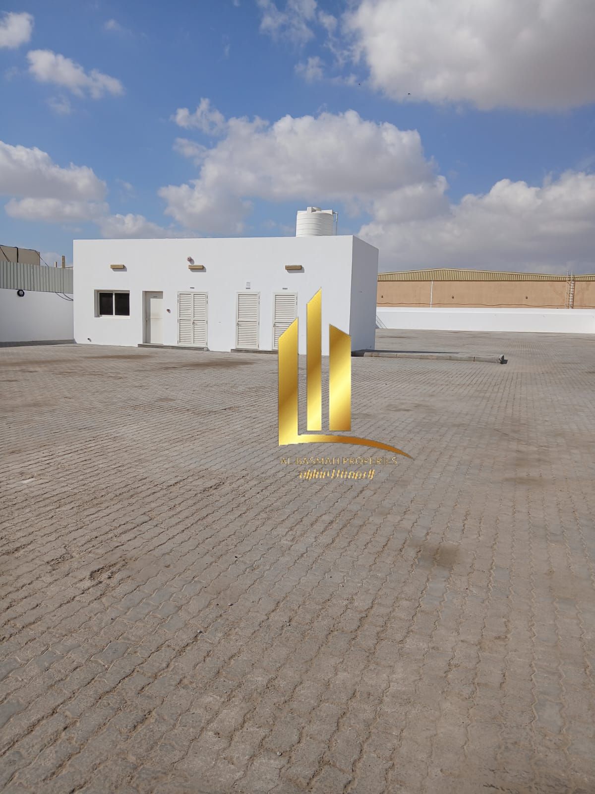 For rent: a fenced plot of land in the Al Sajaa Industrial Area on Emirates Road, with an area of 20,000 square feet.