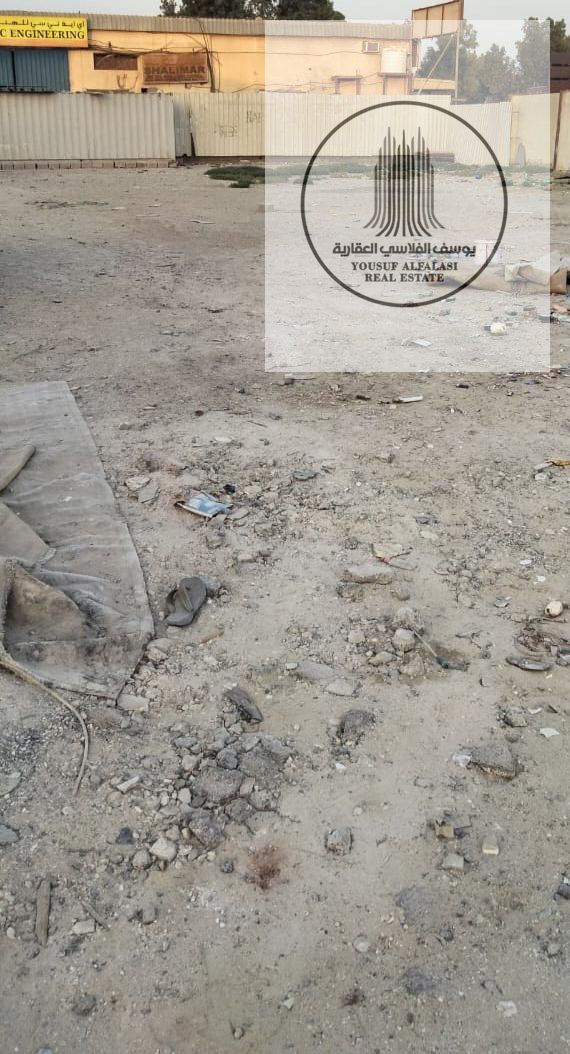 Yard for rent or long-term investment in Sajaa, 10,000 sqft sandy land, no electricity, suitable for storage and open-use activities.
