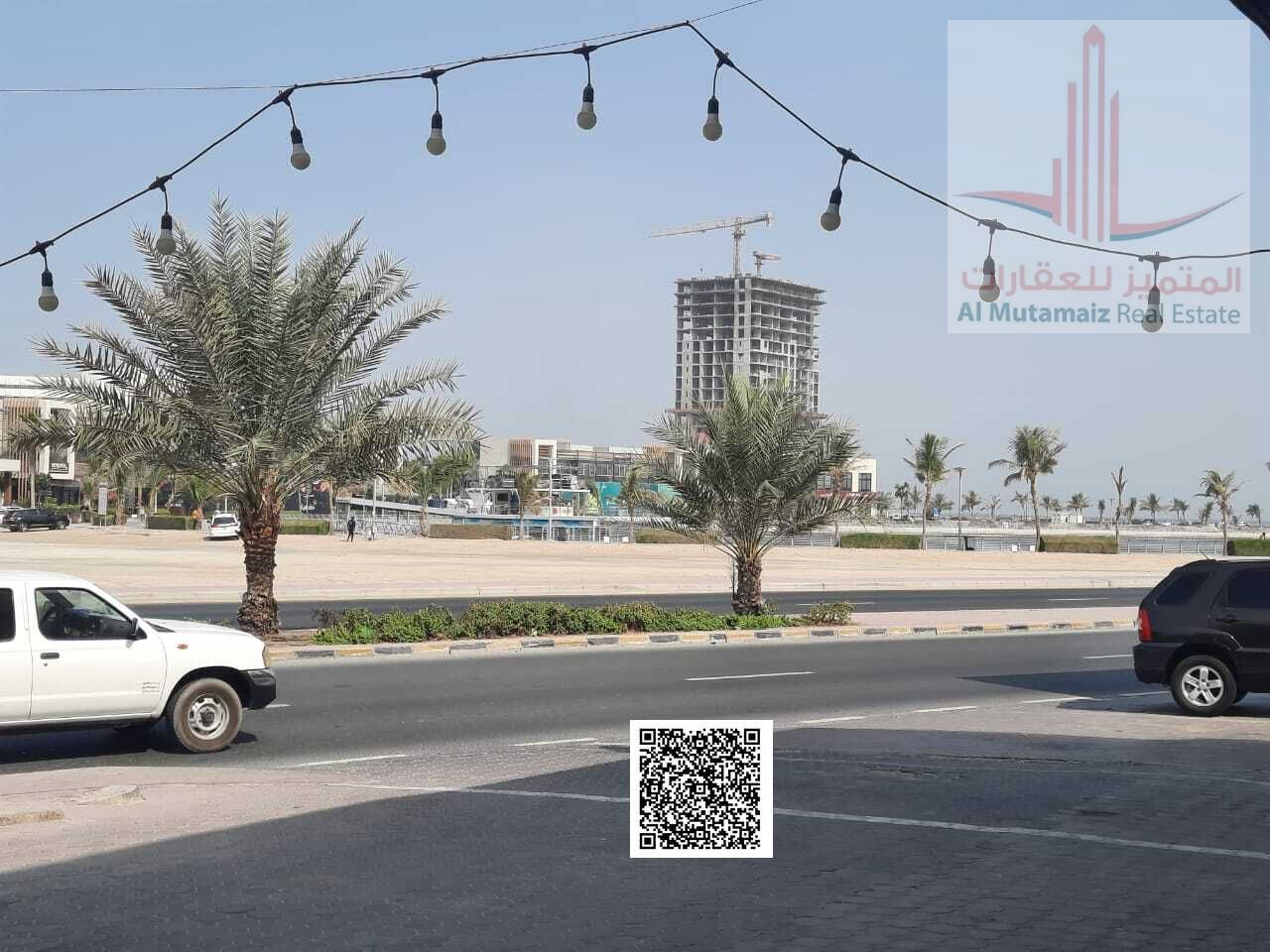 Residential/Commercial Land (Central Ajman), opposite Ajman Marina and Corniche, on a paved road.