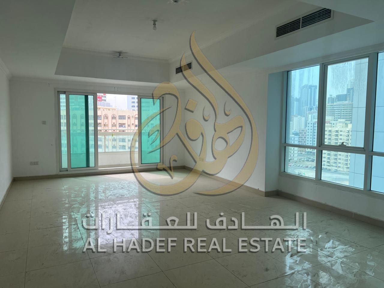 For rent in Sharjah - Al Majaz 2, a two-bedroom apartment with a separate living room, balcony, hallway, and free parking inside the tower.