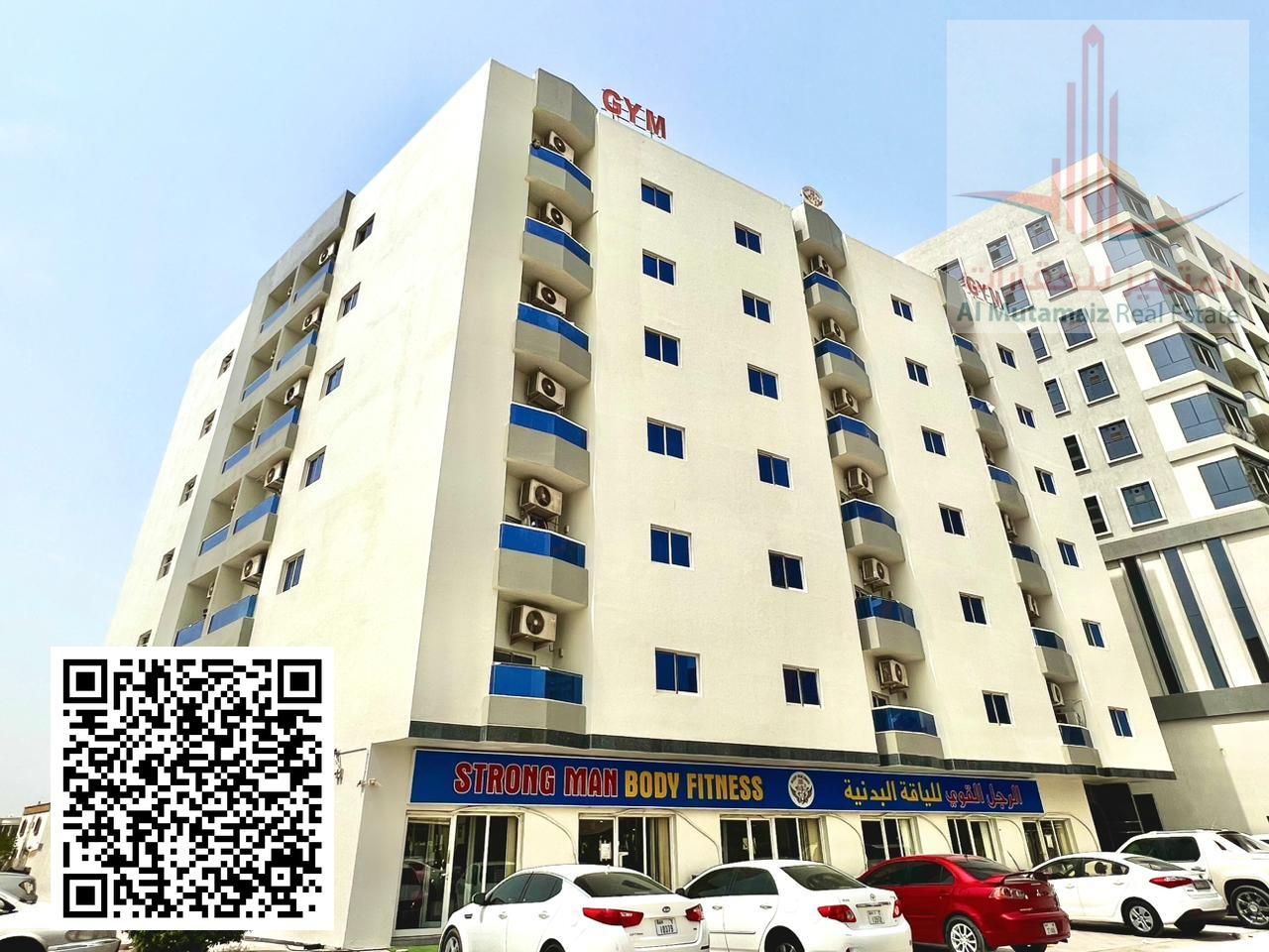Studio apartment with bathroom and kitchen in Al Rawda area. There is a sandy parking area next to the building.