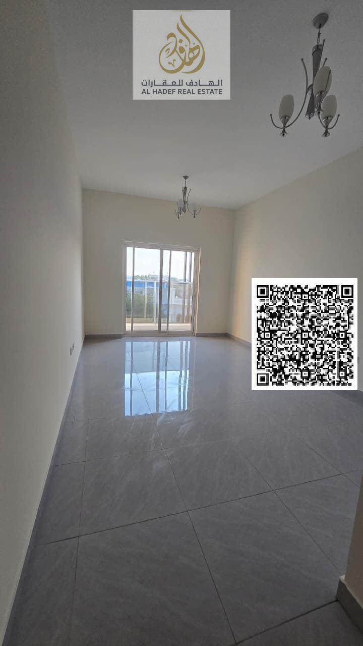 Available in Rawda 1, next to Al Hamidiya Police Station, a brand new building, one-bedroom apartment with a living room, two bathrooms, and a balcony