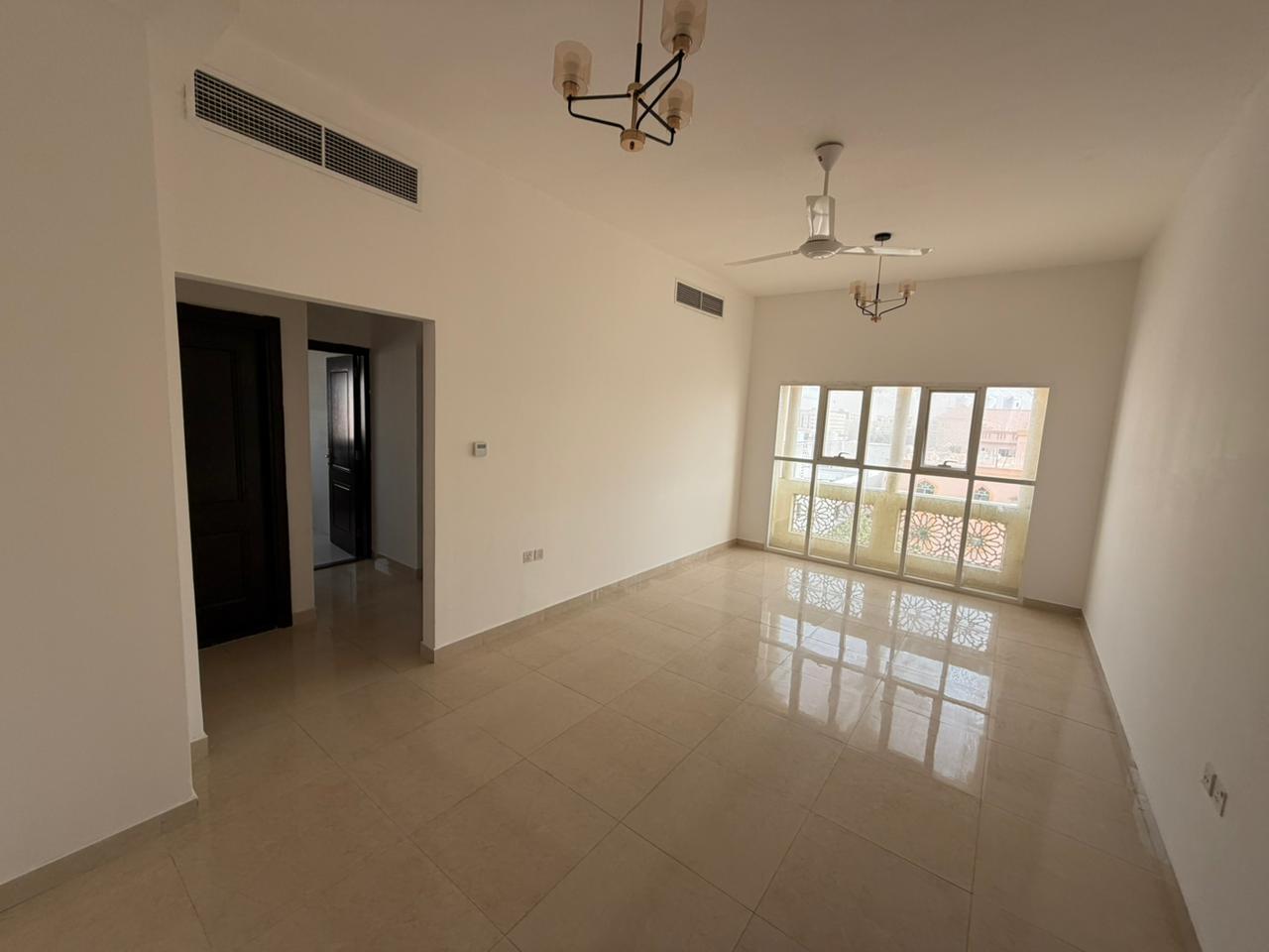 Master bedroom and living room - Al Muwaihat 2 - Annual rent - Family accommodation - Central air conditioning - Free maintenance