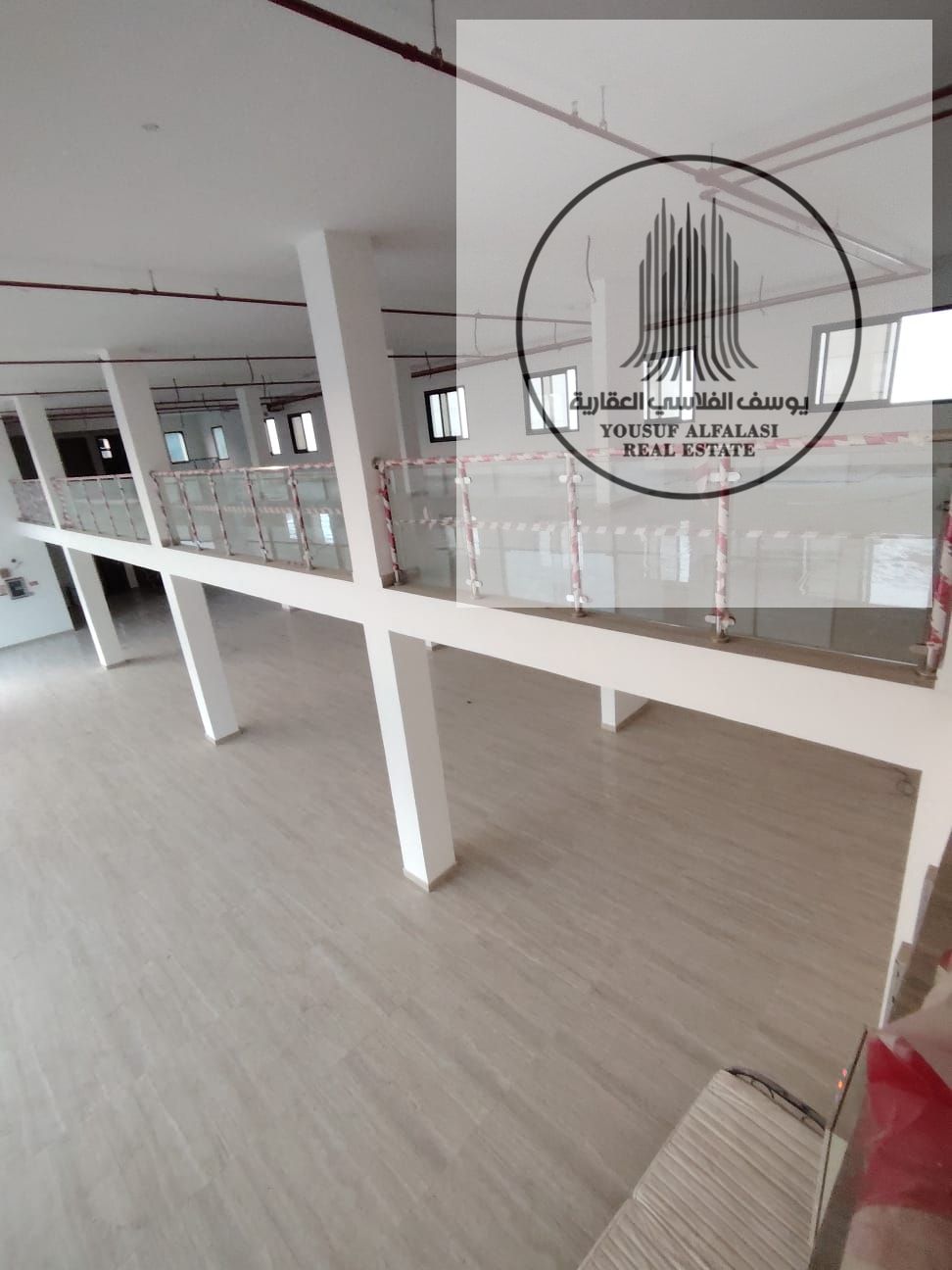 Luxury showroom for rent in Al Jurf Industrial Area 2 – large space with mezzanine, elevator, and ample parking. Area: 8300 sq ft