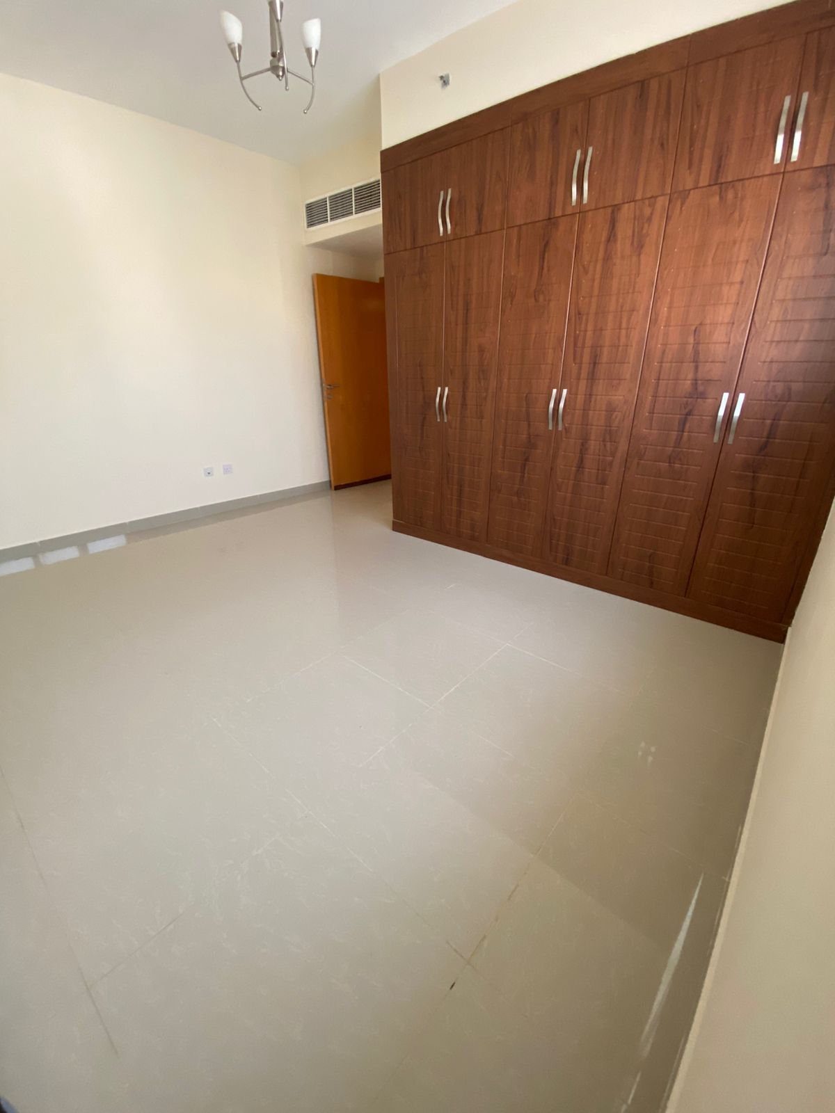 2BR apartment in Boudanq opposite Mega Mall, 2 bathrooms, balcony, built-in wardrobes, central AC, parking, rent AED 45,000.