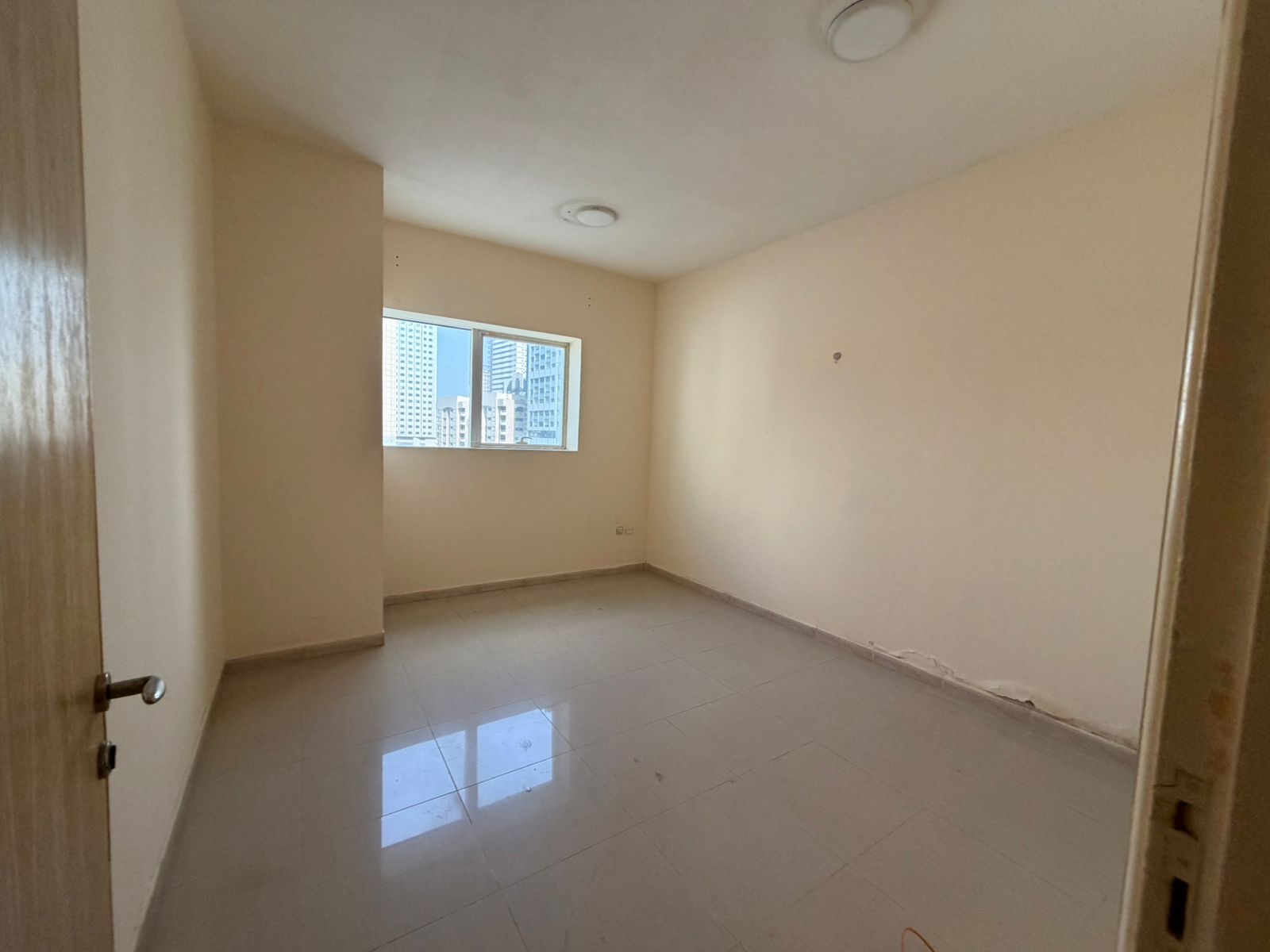 One-bedroom apartment with a hall, sandy parking, spacious areas, prime lively location near services and Dubai exit.