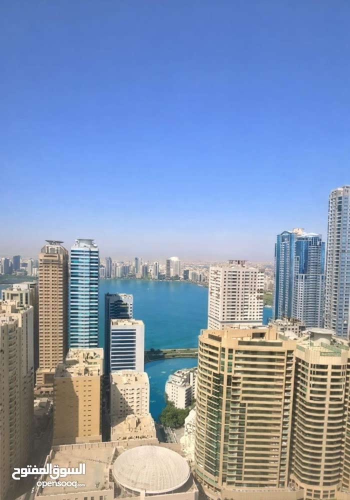 2 master bedroom apartment in Al Qasba, 1,420 sq ft, sea view, 8-year-old building with parking, price AED 590,000.