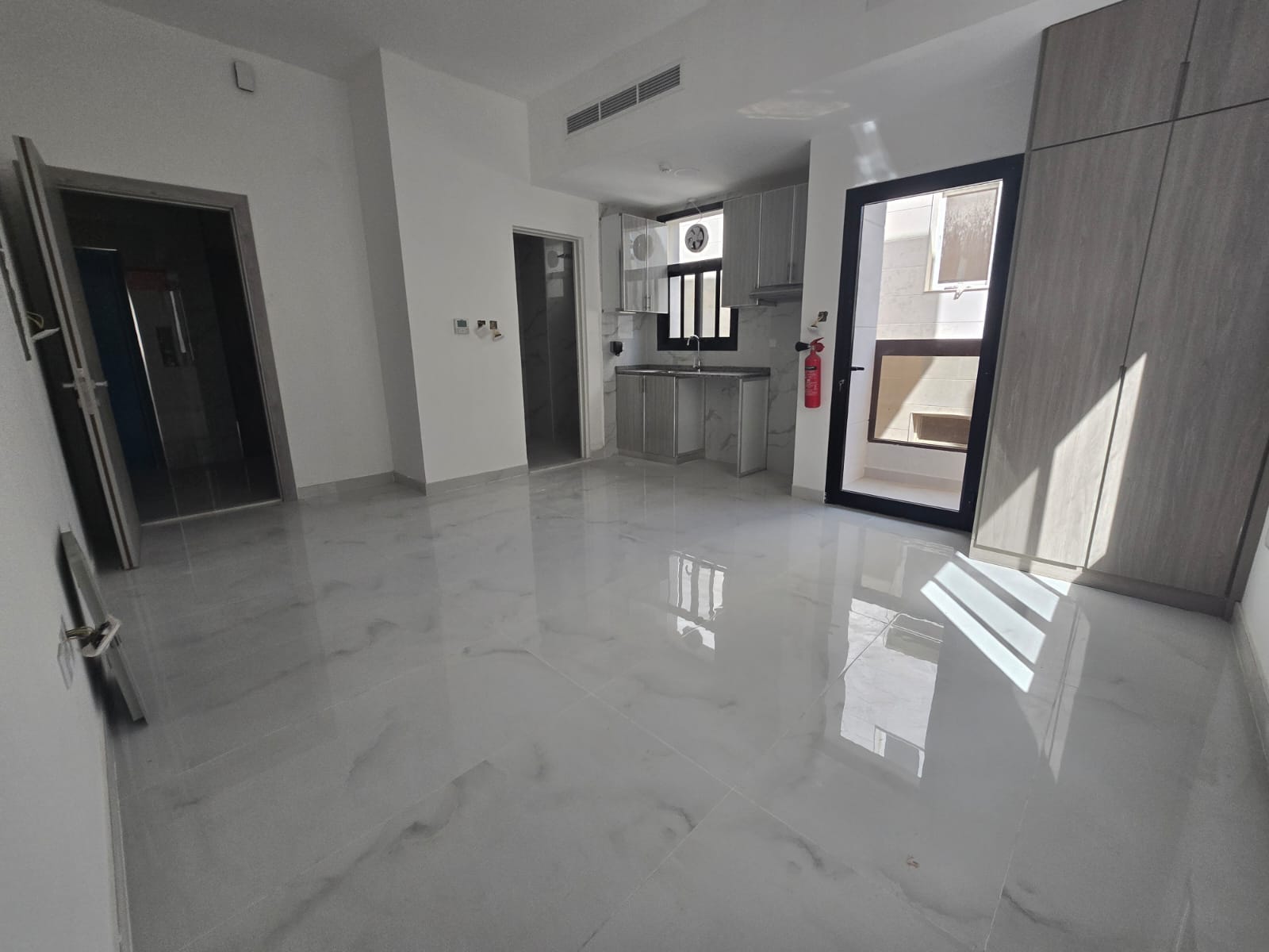 First-time occupancy studio apartment for rent in Al-Aliya – balcony and semi-separate kitchen with central air conditioning and free maintenance