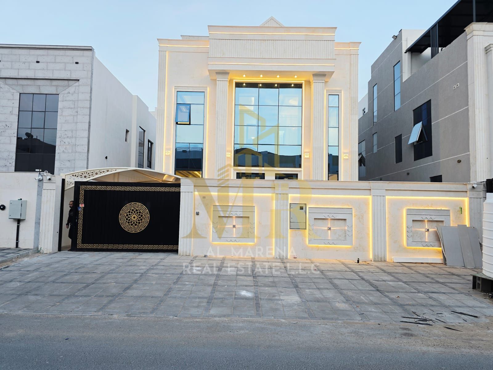 A villa for sale in Al Helio 2, Ajman, with all utilities (electricity, water, and air conditioning) included. Located on the main street opposite the