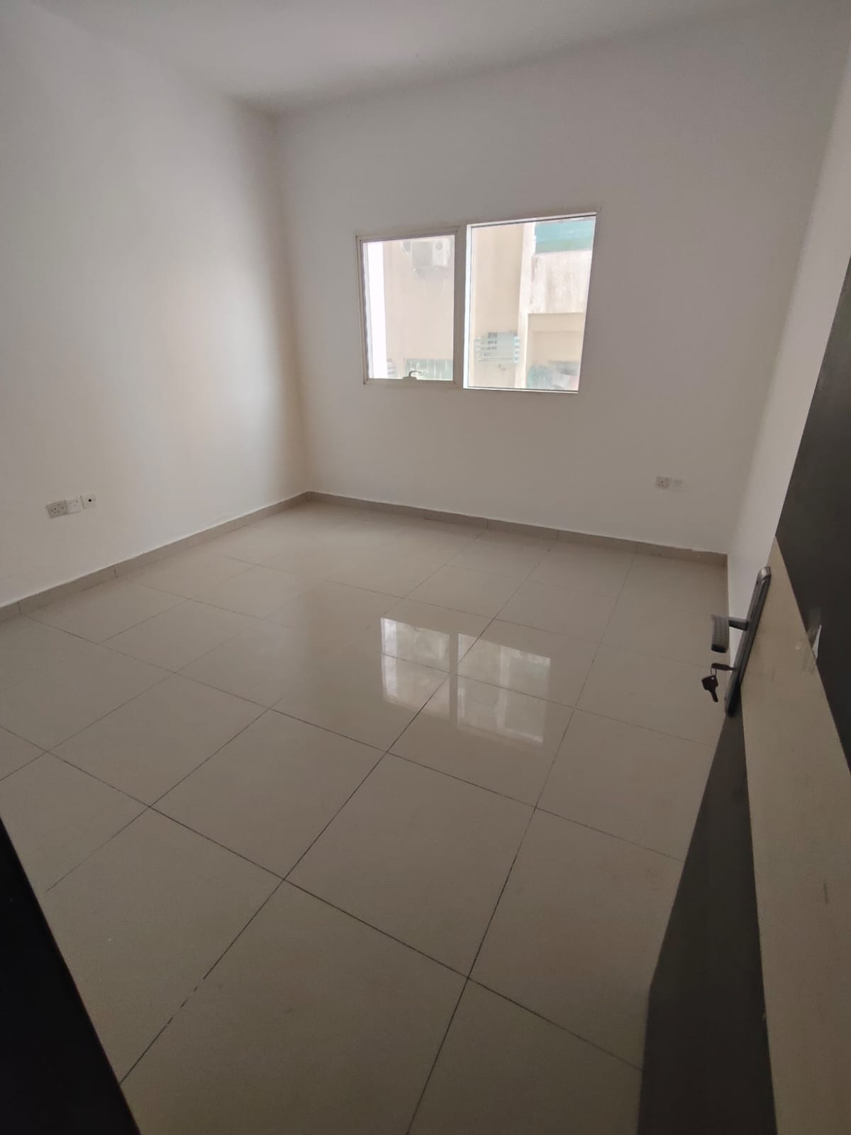 2BR apartment in Al Taawun opposite Nesto, 2 bathrooms, balcony, central AC, spacious layout, prime location near Dubai.