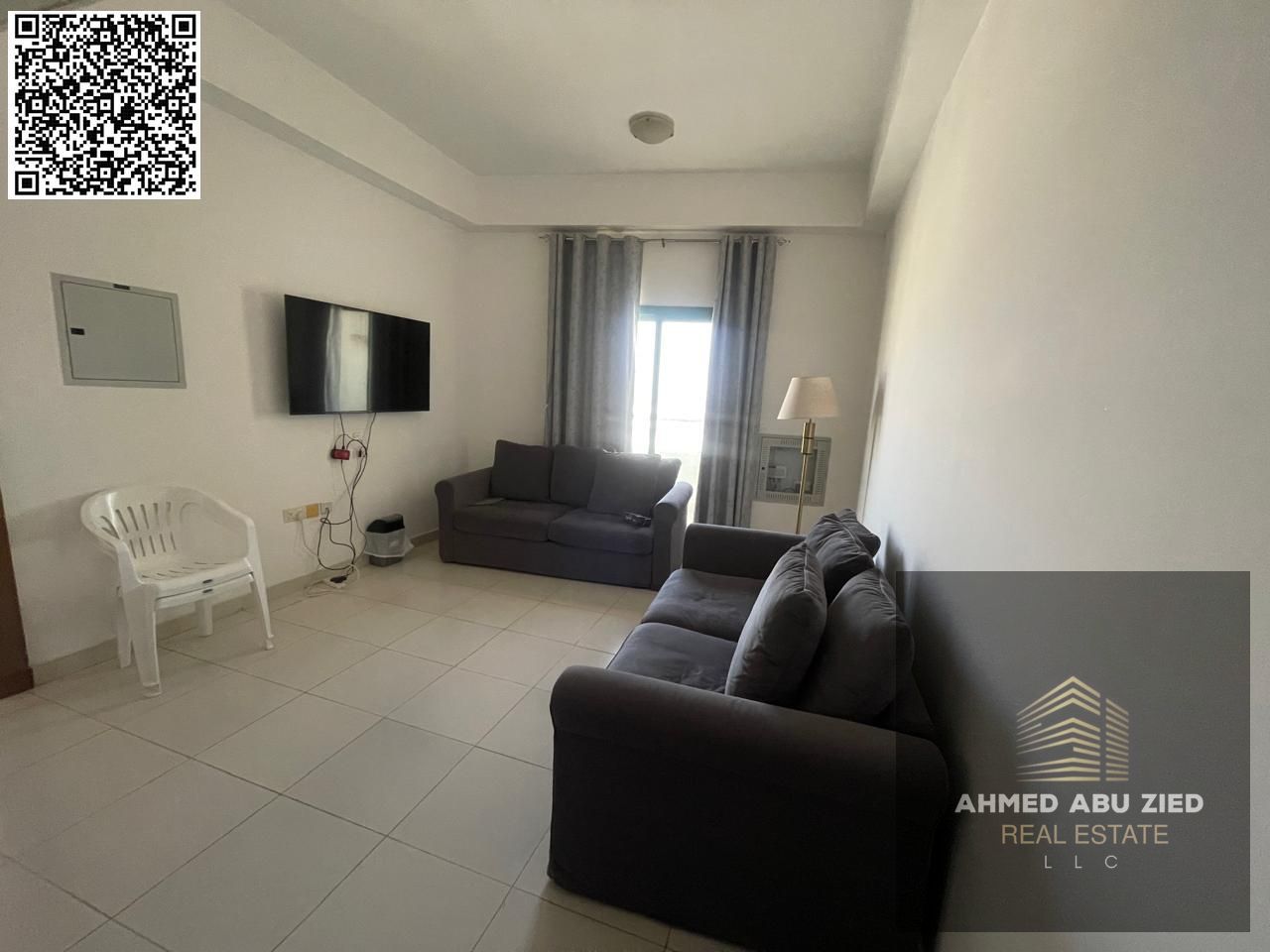 For annual rent in Ajman, a new building offers a furnished one-bedroom apartment with a balcony, open view, spacious living area, and central air con