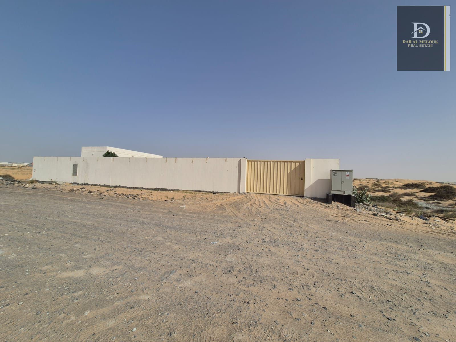 A walled plot of land for rent in Sharjah, Al Sajaa Industrial Area. The plot is 10,000 sq ft and includes an office, a room, a kitchen, and a bathroom. 25kV electricity is available. The asking For inquiries,