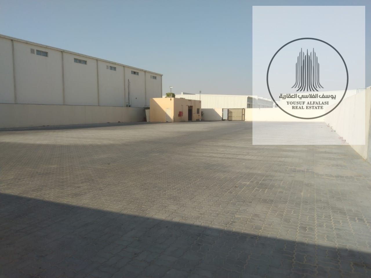 Two adjacent, walled plots of land with a total area of 40,000 square feet on a street.