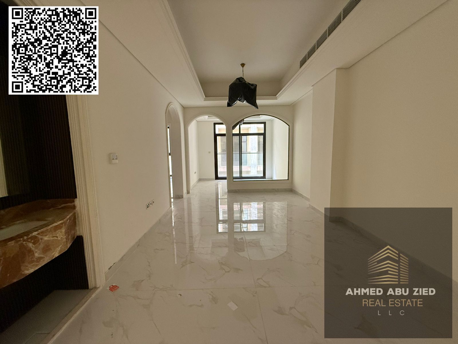 For annual rent in Ajman, a new building offers a two-bedroom apartment with a living room, three bathrooms, a balcony with an open view, spacious lay