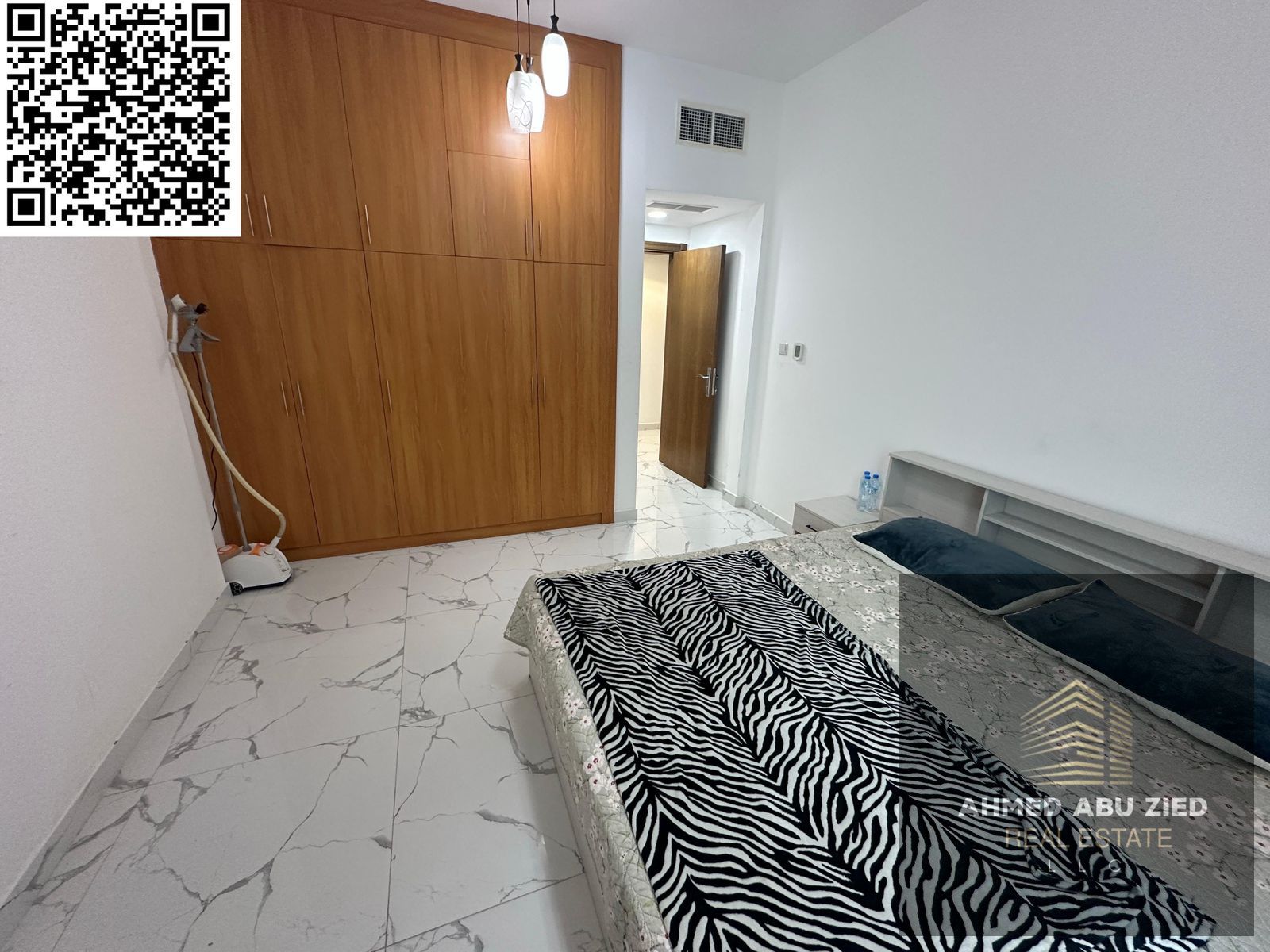 Luxury two-bedroom apartment with a living room, fully furnished, in Al Waha Towers, Ajman, with gym, swimming pool, and three balconies.