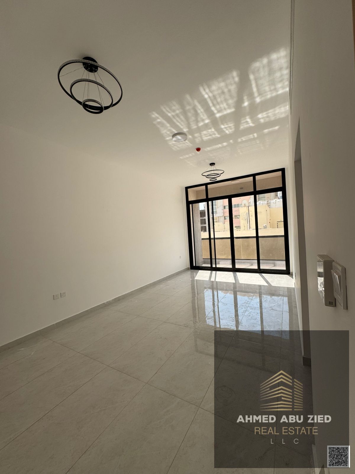 Spacious 1BR apartment, first tenant, 2 bathrooms, balcony, central AC, modern décor & lighting, near all services, easy access to Dubai & Sharjah.